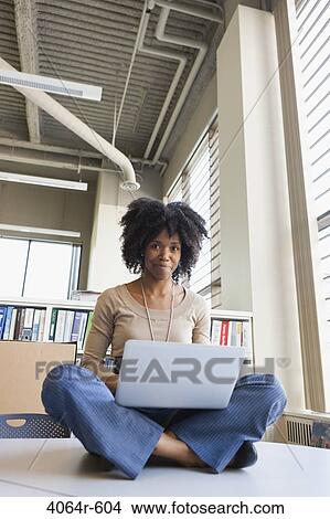 Picture - Portrait of businesswomen using laptop on table in office. Fotosearch