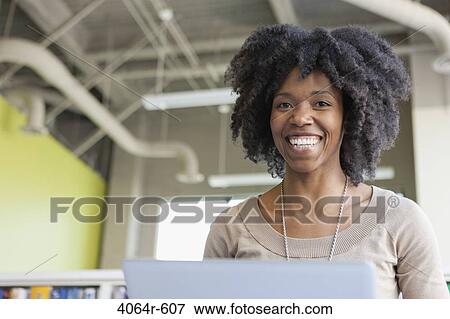 Stock Photo - Portrait of businesswomen using laptop in office. Fotosearch