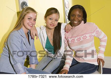 Portrait of cheerful teenage girlfriends sitting together View Large Photo Image Stock Image - Portrait of cheerful teenage girlfriends sitting together. Fotosearch