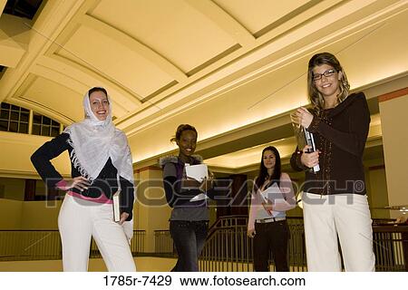 Portrait of four women students standing in the lobby of a building View Large Photo Image Stock Photo - Portrait of four women students standing in the lobby of a building. Fotosearch