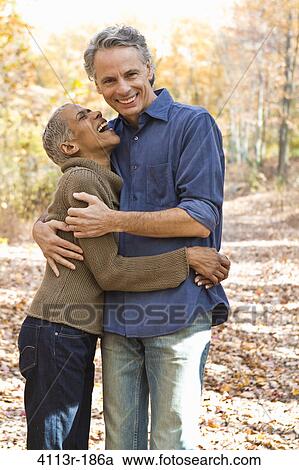 Stock Image - Portrait of mature couple standing on Autumn forest track. Fotosearch