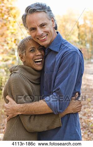 Stock Image - Portrait of mature couple standing on Autumn forest track. Fotosearch