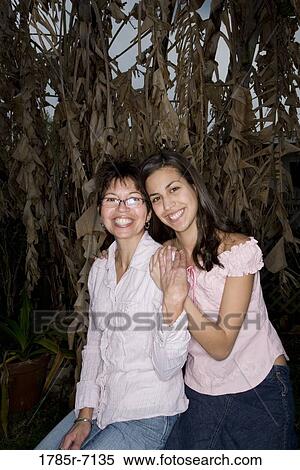 Portrait of Mexican mother and daughter sitting together View Large Photo Image Stock Photography - Portrait of Mexican mother and daughter sitting together. Fotosearch