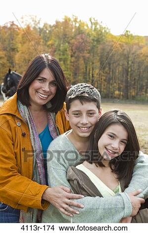 Portrait of mother with two children on field View Large Photo Image Picture - Portrait of mother with two children on field. Fotosearch