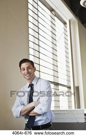 Portrait of smiling businessman in office View Large Photo Image Stock Photograph - Portrait of smiling businessman in office. Fotosearch