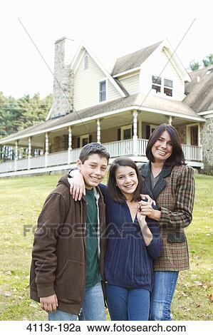 Portrait of smiling mother with two children standing in front of large house View Large Photo Image Stock Image - Portrait of smiling mother with two children standing in front of large house. Fotosearch