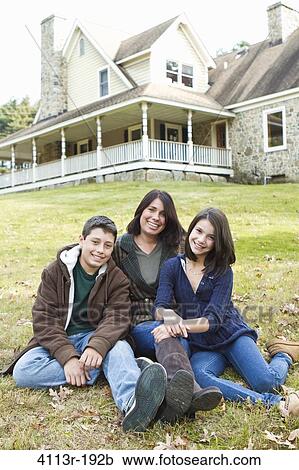 Portrait of smiling mother with two children sitting in front of large house View Large Photo Image Stock Image - Portrait of smiling mother with two children sitting in front of large house. Fotosearch