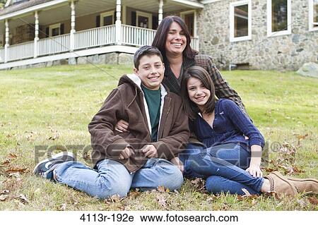 Portrait of smiling mother with two children sitting in front of large house View Large Photo Image Stock Image - Portrait of smiling mother with two children sitting in front of large house. Fotosearch