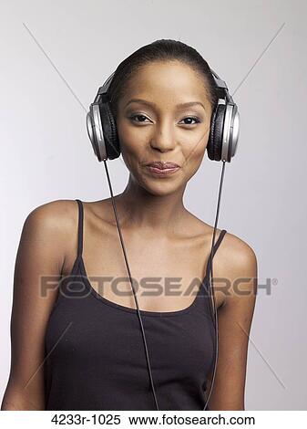 Portrait of smiling young woman enjoying music on headphones View Large Photo Image Stock Photography - Portrait of smiling young woman enjoying music on headphones. Fotosearch