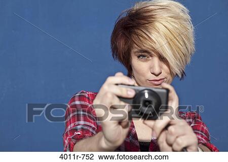 Stock Image - Portrait of teenage girl using digital camera. Fotosearch