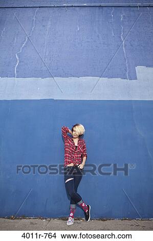 Portrait of teenage girl with dyed hair, wearing torn jeans, lumberjack shirt and pair of two different shoes View Large Photo Image Picture - Portrait of teenage girl with dyed hair, wearing torn jeans, lumberjack shirt and pair of two different shoes. Fotosearch