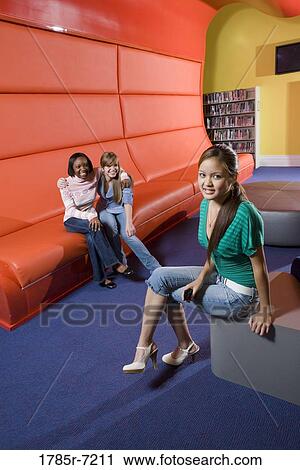 Portrait of teenage girlfriends sitting in the library View Large Photo Image Stock Image - Portrait of teenage girlfriends sitting in the library. Fotosearch