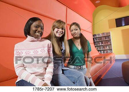 Portrait of teenage girlfriends sitting in the library View Large Photo Image Stock Photo - Portrait of teenage girlfriends sitting in the library. Fotosearch