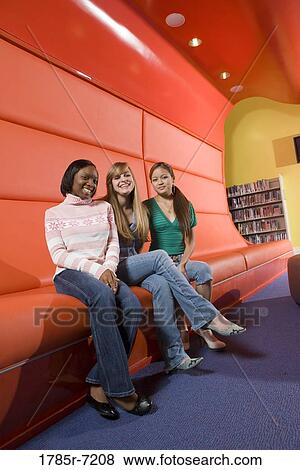 Portrait of teenage girlfriends sitting in the library View Large Photo Image Stock Photo - Portrait of teenage girlfriends sitting in the library. Fotosearch