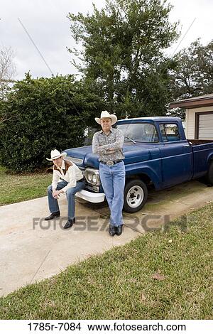 Portrait of Tex-Mex father and son by a pick-up truck in front of house View Large Photo Image Picture - Portrait of Tex-Mex father and son by a pick-up truck in front of house. Fotosearch
