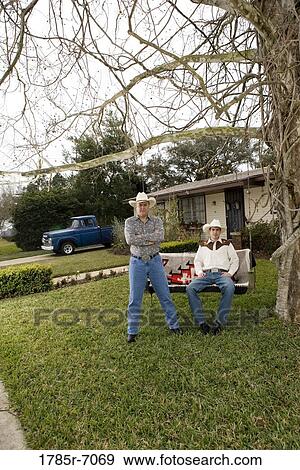Portrait of Tex-Mex father and son in in front yard of house View Large Photo Image Stock Photo - Portrait of Tex-Mex father and son in in front yard of house. Fotosearch