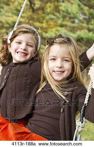 Portrait of two girls on swing View Large Photo Image Stock Image - Portrait of two girls on swing. Fotosearch