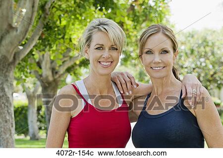 Portrait of two mature women smiling with arm around each other View Large Photo Image Stock Image - Portrait of two mature women smiling with arm around each other. Fotosearch