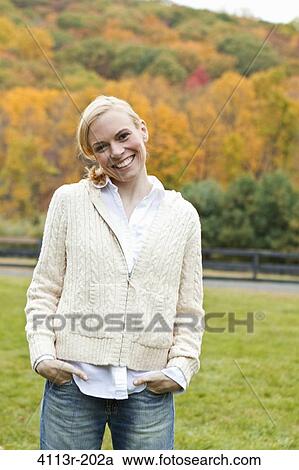 Stock Image - Portrait of woman standing on field. Fotosearch