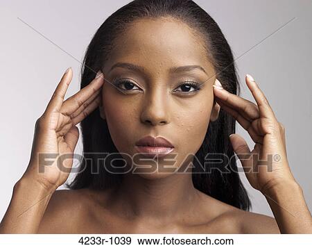 Portrait of young woman holding head View Large Photo Image Stock Photo - Portrait of young woman holding head. Fotosearch