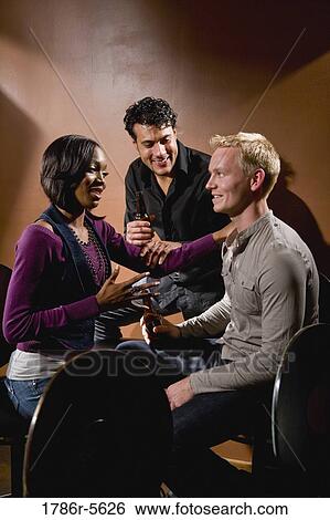 Pretty young woman chatting with two men View Large Photo Image Stock Photograph - Pretty young woman chatting with two men. Fotosearch