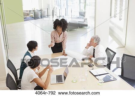 Stock Image - Project discussions amongst employees in boardroom. Fotosearch