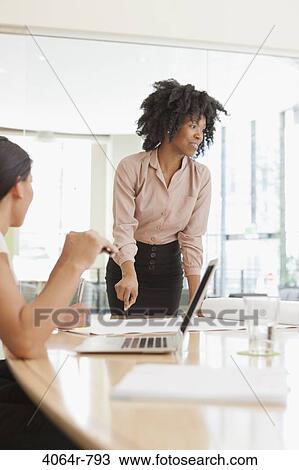 Stock Image - Project discussions amongst employees in boardroom. Fotosearch