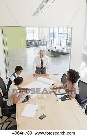 Stock Photo - Project discussions amongst employees in boardroom. Fotosearch