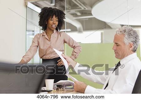 Stock Photograph - Project discussions amongst employees in boardroom. Fotosearch