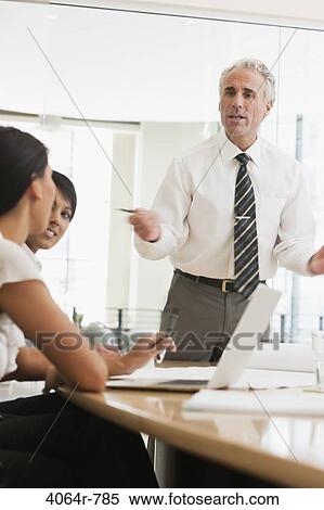 Stock Photography - Project discussions amongst employees in boardroom. Fotosearch