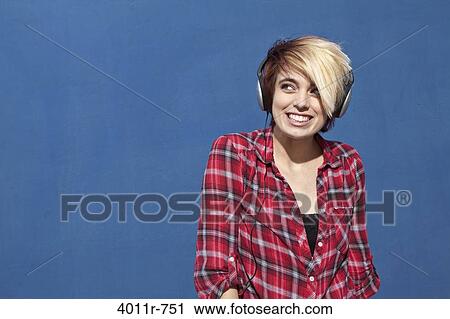 Stock Image - Punk girl wearing headphones, smiling. Fotosearch