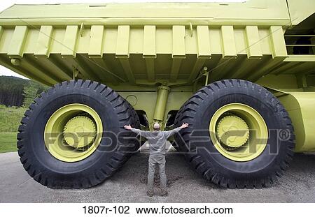 Rear view of a man standing near an earth mover View Large Photo Image Stock Image - Rear view of a man standing near an earth mover. Fotosearch
