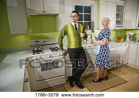 Stock Photo - Retro couple at home in kitchen chatting. Fotosearch
