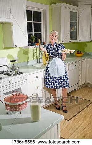 Stock Photography - Retro housewife in kitchen with cookies. Fotosearch