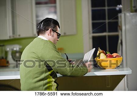Retro man reading newspaper in kitchen View Large Photo Image Stock Image - Retro man reading newspaper in kitchen. Fotosearch