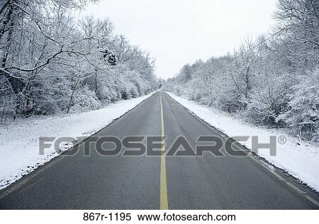 Stock Photography - Road passing through a snow covered landscape. Fotosearch