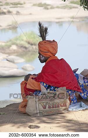 Picture - Sadhu sitting at a riverside, Hampi, Karnataka, India. Fotosearch