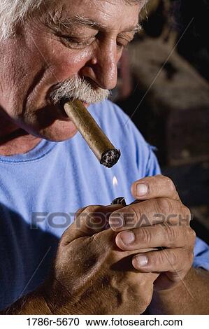 Senior man lighting up cigar View Large Photo Image Stock Image - Senior man lighting up cigar. Fotosearch