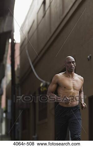 Shirtless man jogging in street View Large Photo Image Stock Photo - Shirtless man jogging in street. Fotosearch