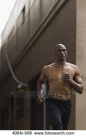 Stock Photo - Shirtless man jogging in street. Fotosearch