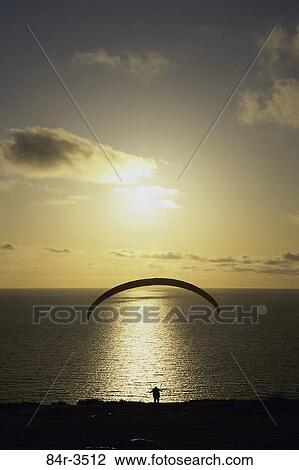 Silhouette of a parasailor at sunset View Large Photo Image Stock Image - Silhouette of a parasailor at sunset. Fotosearch