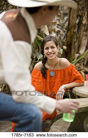 Smiling young Mexican woman looking up at young man View Large Photo Image Stock Image - Smiling young Mexican woman looking up at young man. Fotosearch