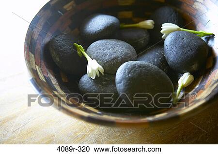 Stones and tuberose flowers in bowl View Large Photo Image Stock Image - Stones and tuberose flowers in bowl. Fotosearch