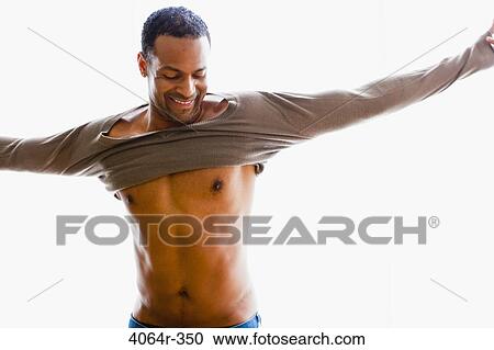 Stock Image - Studio portrait of man getting dressed. Fotosearch