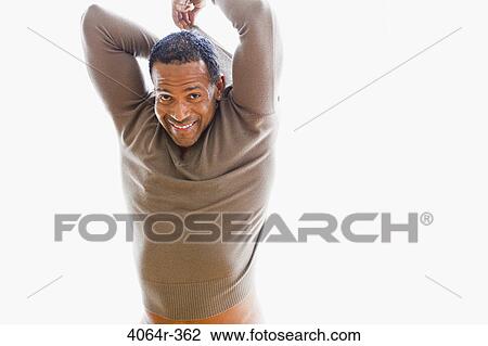 Stock Image - Studio portrait of man getting dressed. Fotosearch