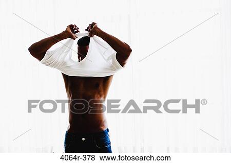 Stock Photo - Studio portrait of man getting dressed. Fotosearch
