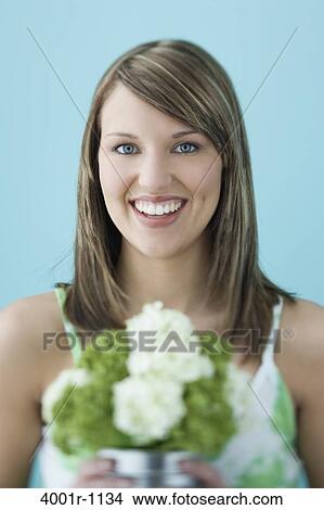 Studio portrait of young woman holding flowers View Large Photo Image Picture - Studio portrait of young woman holding flowers. Fotosearch