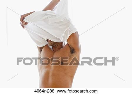 Stock Photo - Studio shot of man getting dressed. Fotosearch
