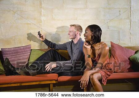 Picture - Stylish young interracial couple reading text message. Fotosearch
