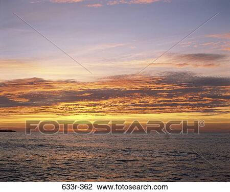 Stock Image - Sunrise over the ocean. Fotosearch